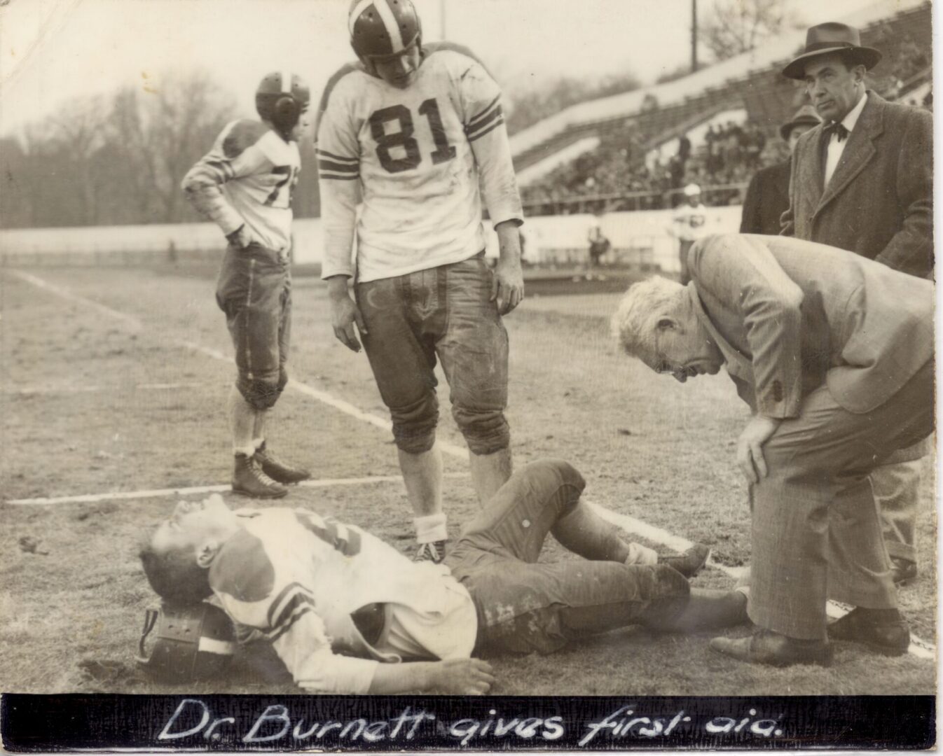 Vintage football player receiving on-field medical attention