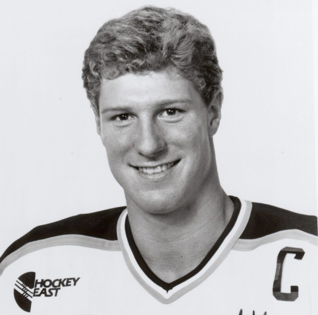 Smiling hockey player portrait wearing captain's jersey