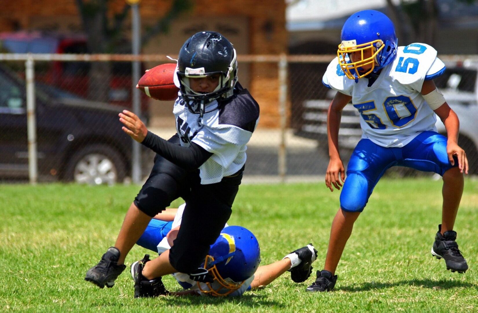 Youth football players tackling during game