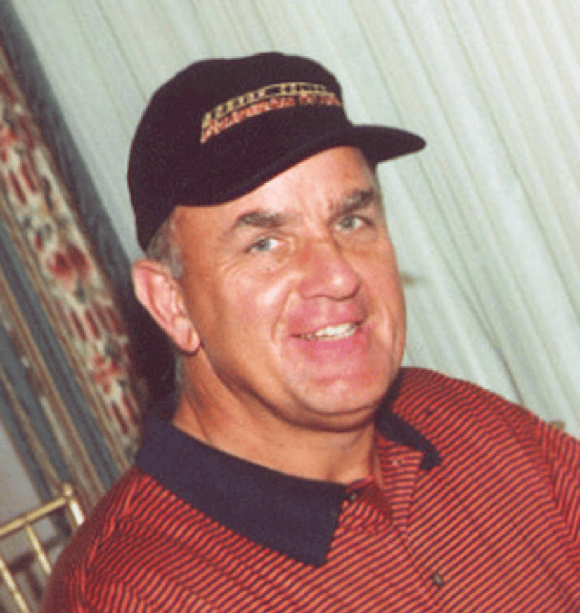 Smiling man in black cap and striped polo