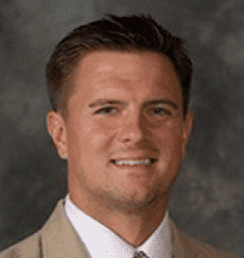 Headshot of smiling man in tan suit