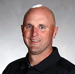 Smiling bald man in black collared shirt