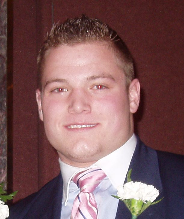 Smiling man in suit, pink tie, boutonniere