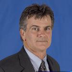 Headshot of man wearing suit and tie