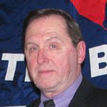 Middle-aged man in suit before blue banner