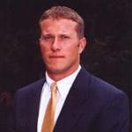Man in dark suit and yellow tie