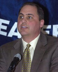 Man in suit speaking at microphone