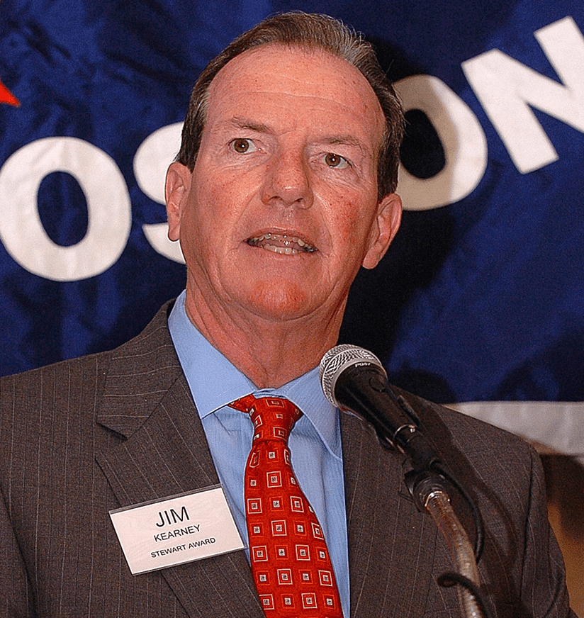 Person in suit speaking at podium microphone