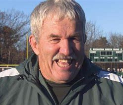 Smiling man with mustache near scoreboard