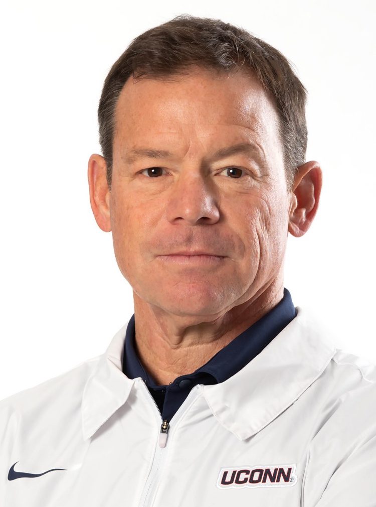 Man wearing UConn jacket against white background