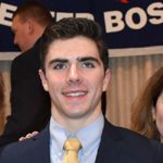 Smiling young man wearing a suit and yellow tie
