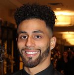 Smiling young man with curly hair and beard
