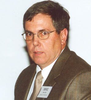 Man in suit and glasses with name badge