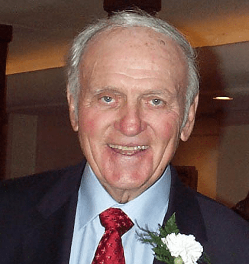 Older man smiling in suit with boutonniere