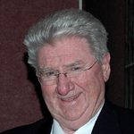 Older man smiling in suit