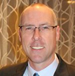 Smiling man wearing suit and glasses