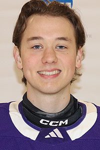 Smiling young hockey player in purple jersey