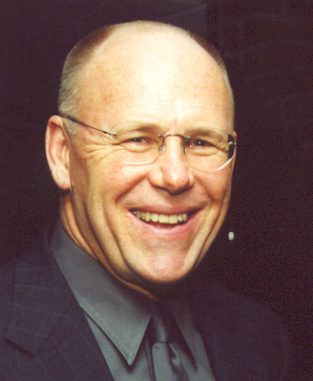 Smiling bald man wearing glasses and suit
