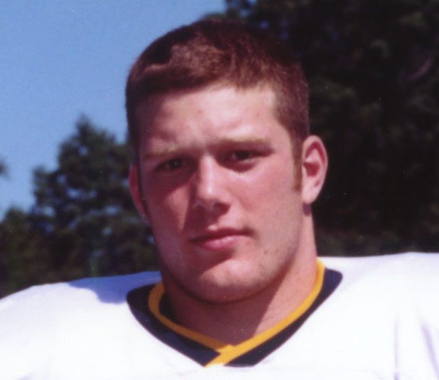Close-up young football player in white uniform